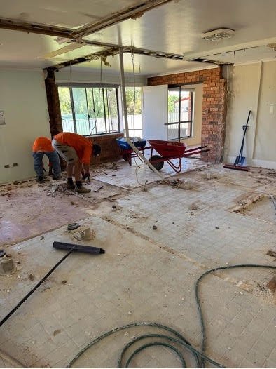 Workers removing floor tiles during commercial strip out